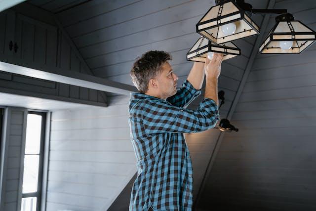 person changing a light bulb